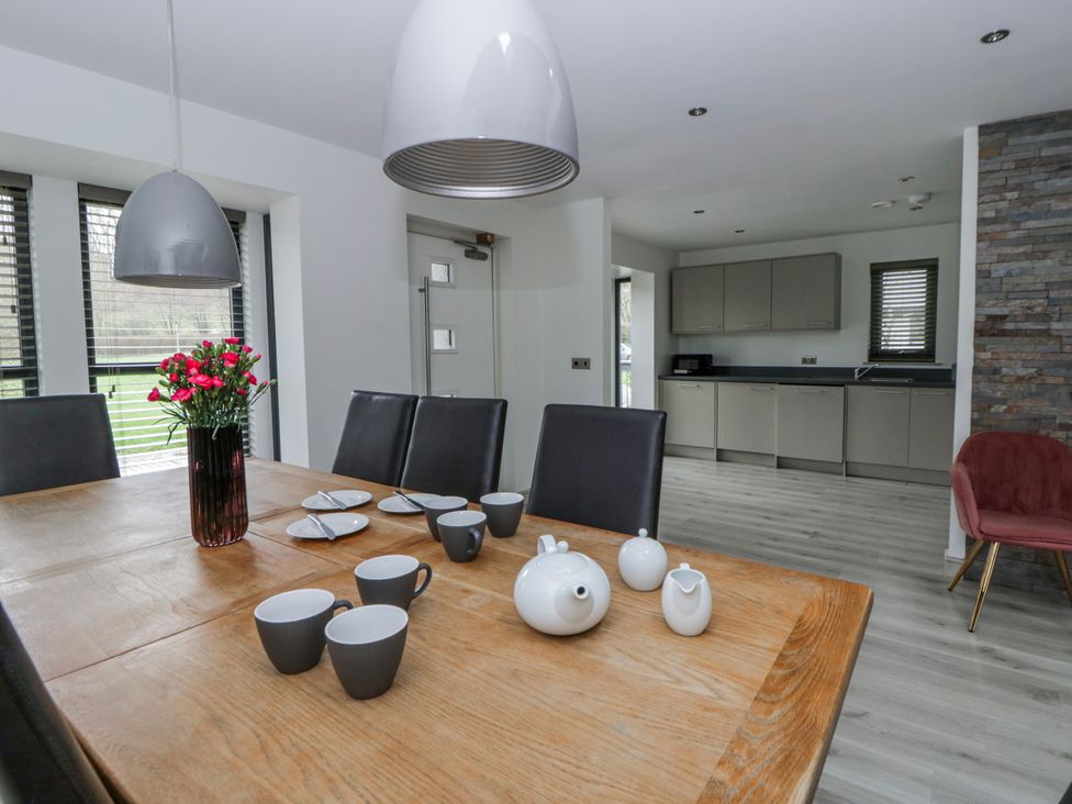 A dining room with a wooden table and chairs at Oak Lodge in Knighton