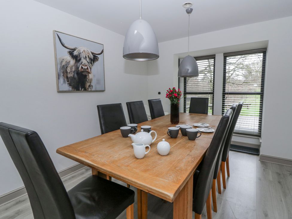 A dining room with a wooden table and chairs at Oak Lodge in Knighton