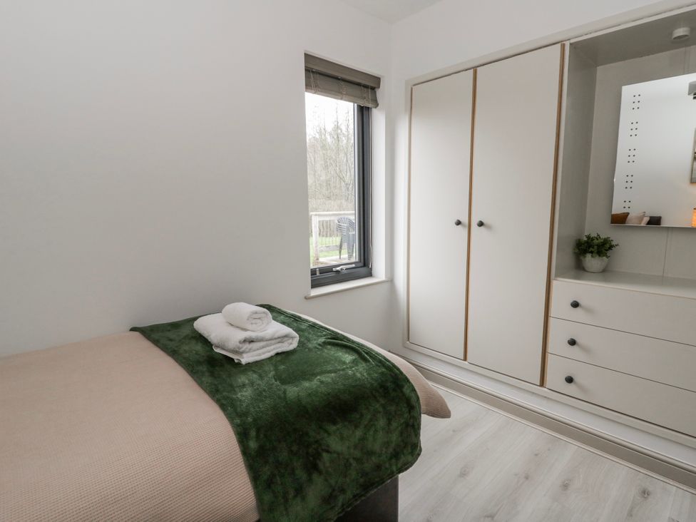 A bedroom with a bed and wardrobe at Oak Lodge Knighton