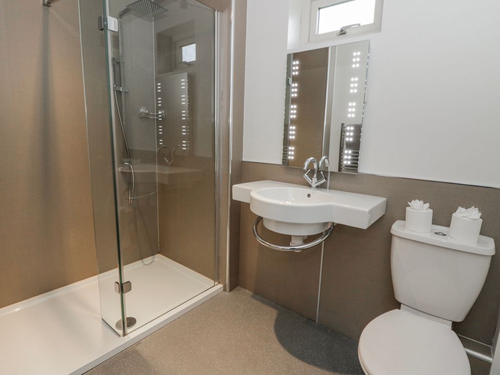 A bathroom with a shower, sink, and toilet at Oak Lodge in Knighton