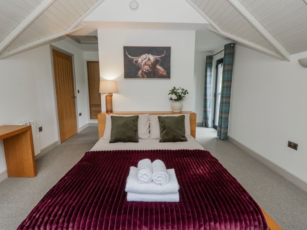 A bedroom with a bed and lamp at Oak Lodge in Knighton