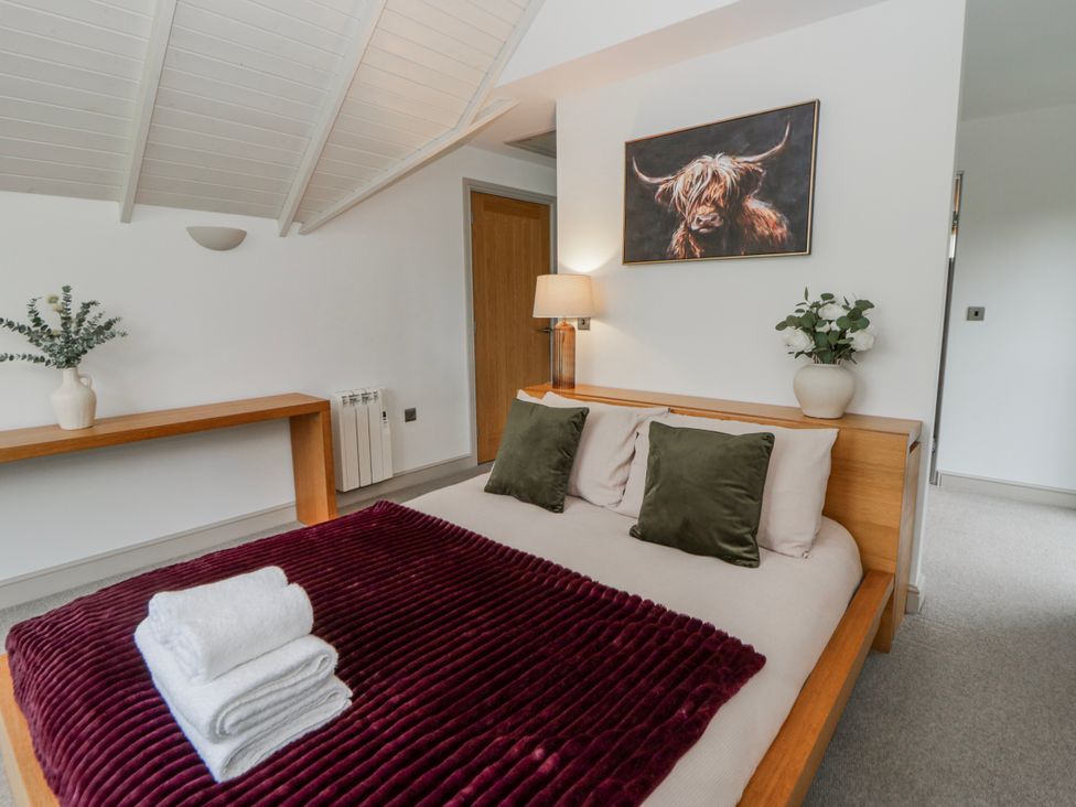 A bedroom with a bed and a lamp at Oak Lodge in Knighton