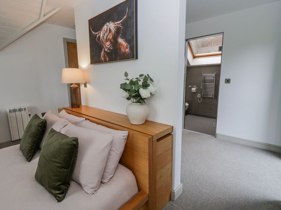 A bedroom with a bed and a door leading to a bathroom at Oak Lodge in Knighton