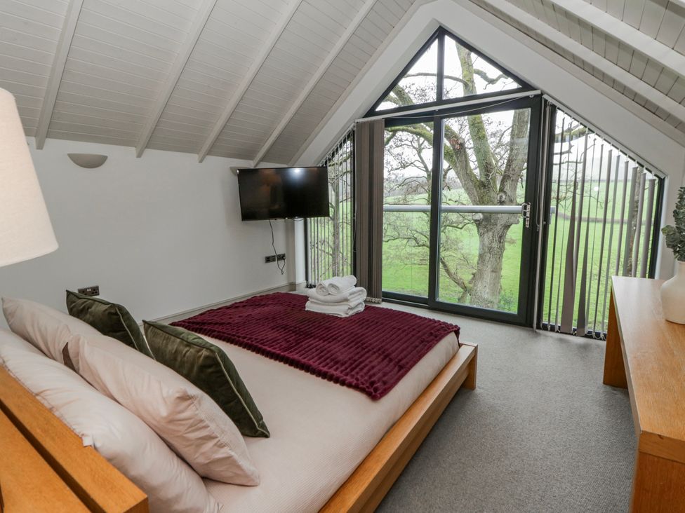 A bedroom with a bed and television at Oak Lodge in Knighton