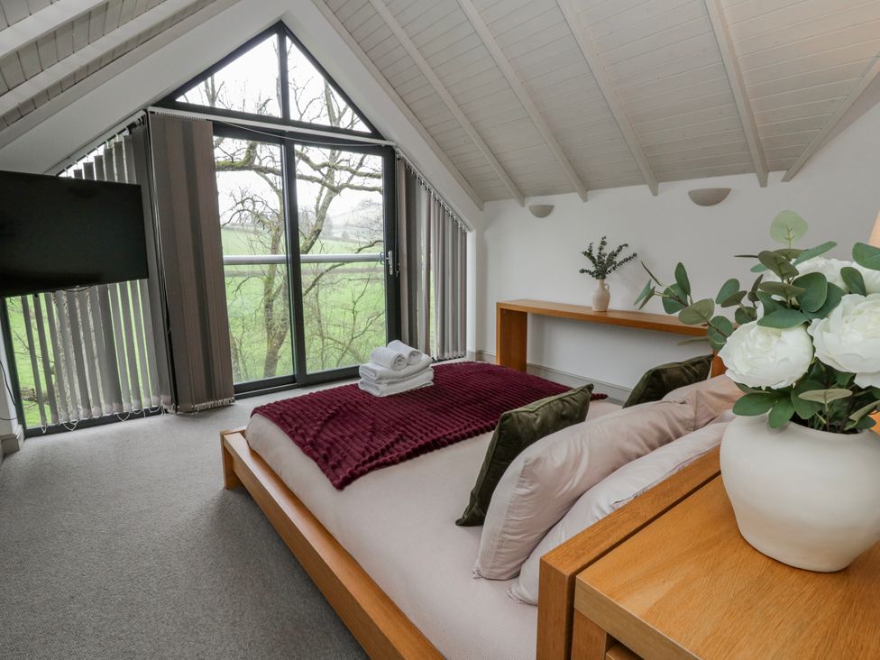 A bedroom with a bed and television at Oak Lodge in Knighton