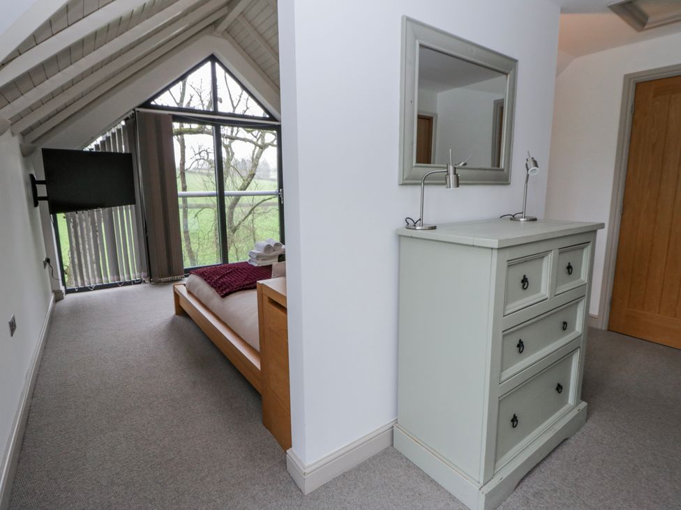 A bedroom with a dresser and television at Oak Lodge in Knighton