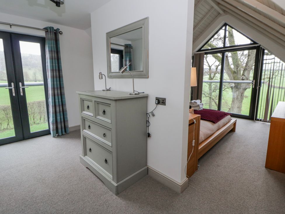 A bedroom with a drawer unit and bed at Oak Lodge in Knighton