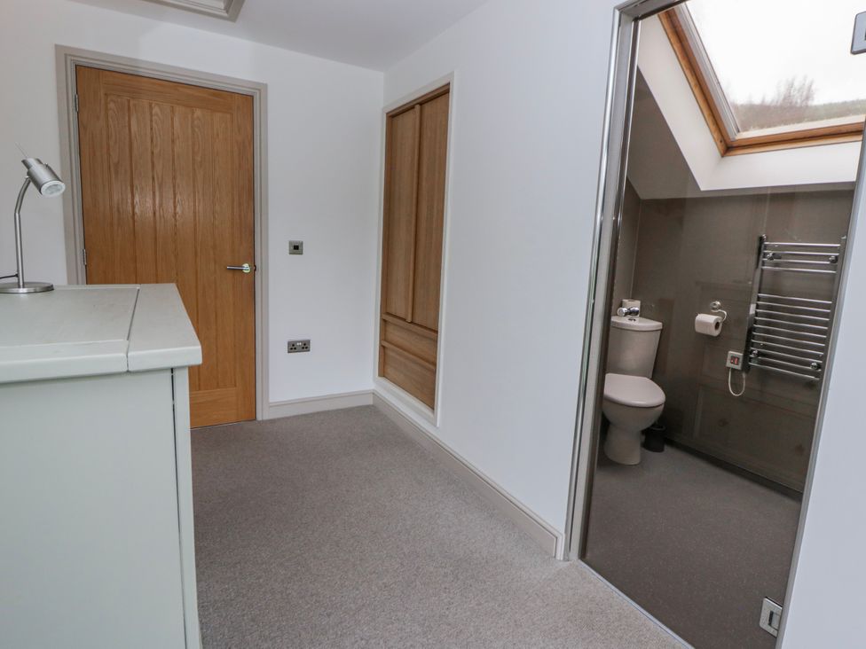 A bathroom with a toilet and towel rail at Oak Lodge in Knighton