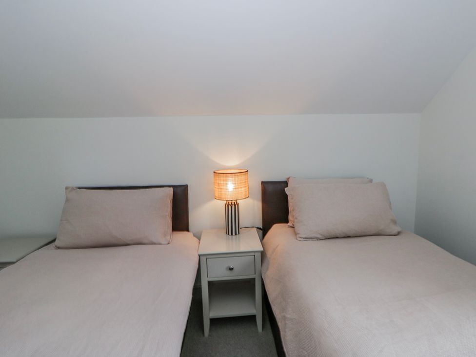 A bedroom with two beds and a lamp at Oak Lodge in Knighton