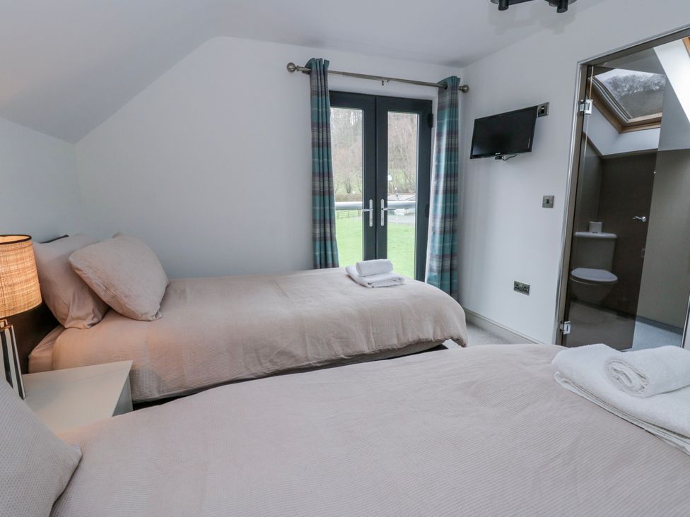 A bedroom with twin beds and a television at Oak Lodge in Knighton