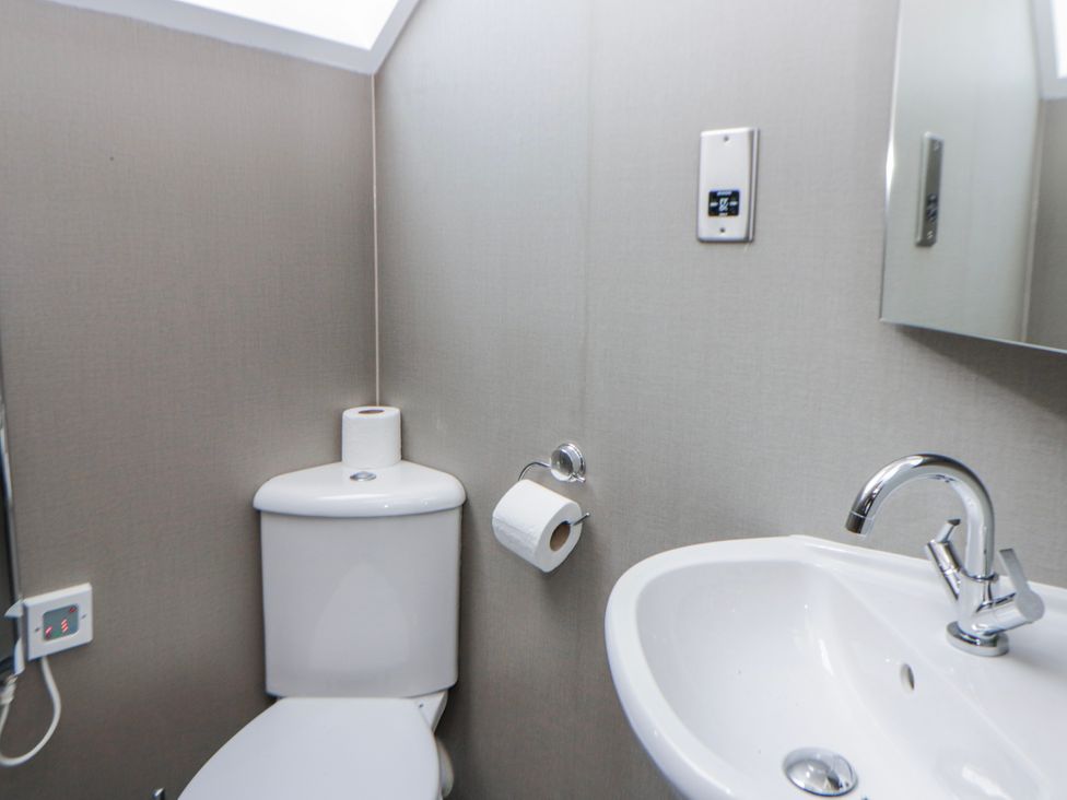 A bathroom with a toilet and wash basin at Oak Lodge in Knighton