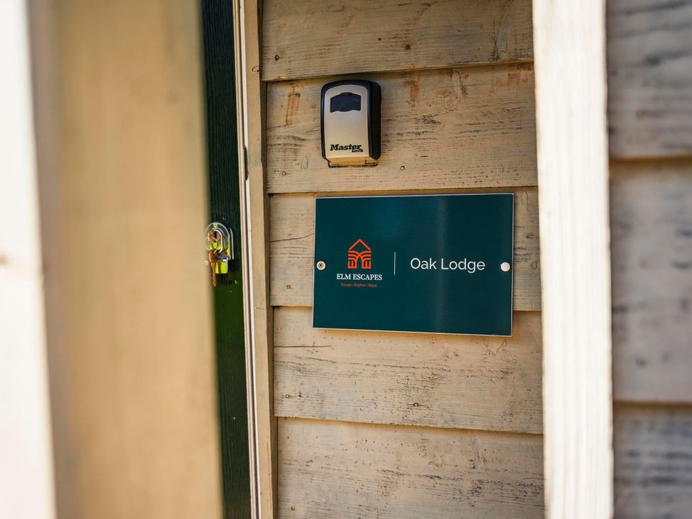 An entrance with a door and sign at Oak Lodge in Llangunllo