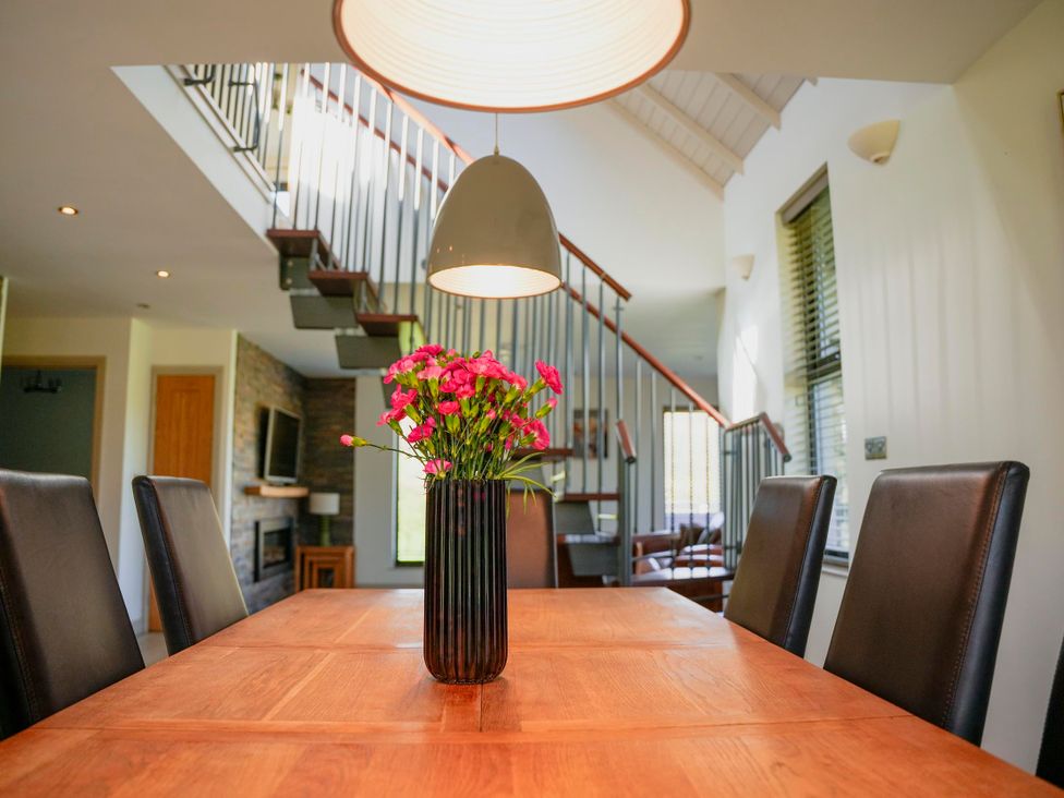 A dining room with a table and chairs at Oak Lodge in Llangunllo