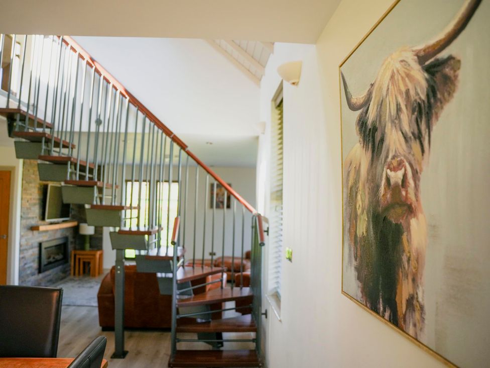 A living room with a staircase and a painting at Oak Lodge in Llangunllo