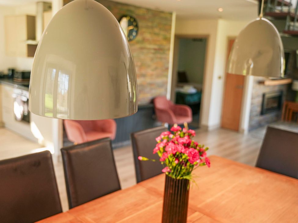 A dining room with a table and pendant light at Oak Lodge in Llangunllo