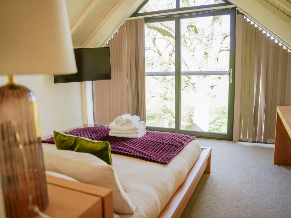 A bedroom with a bed and towels at Oak Lodge in Llangunllo