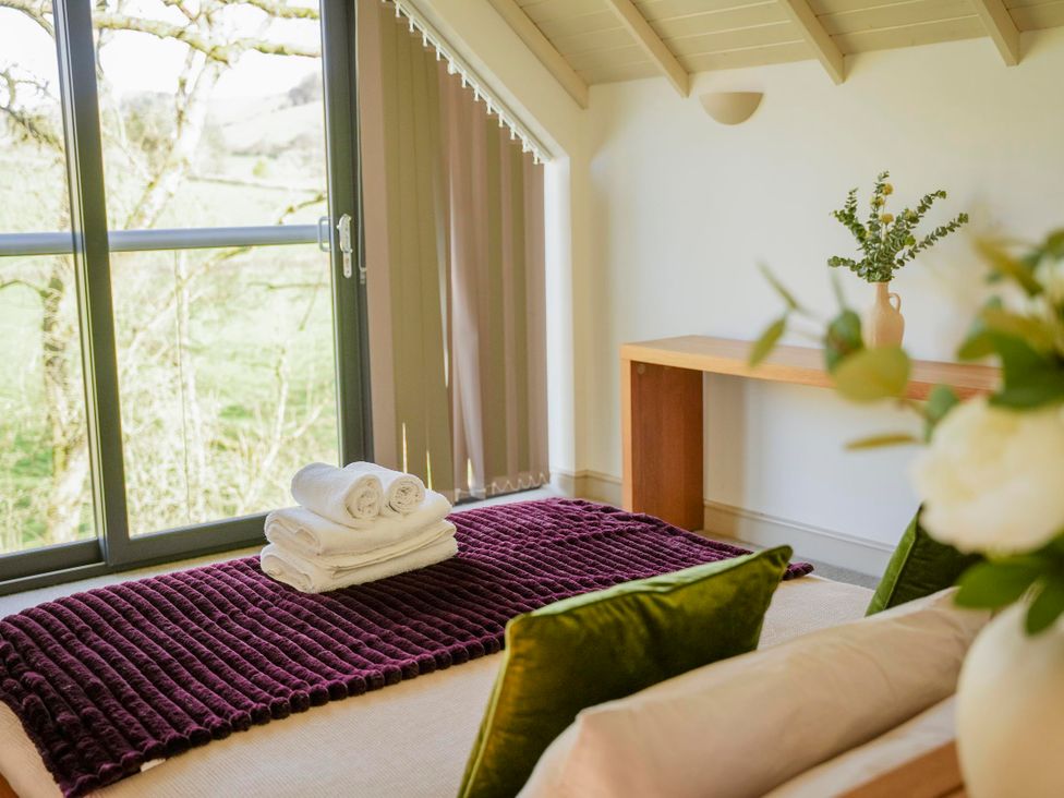 A sitting room with towels and a table at Oak Lodge in Llangunllo