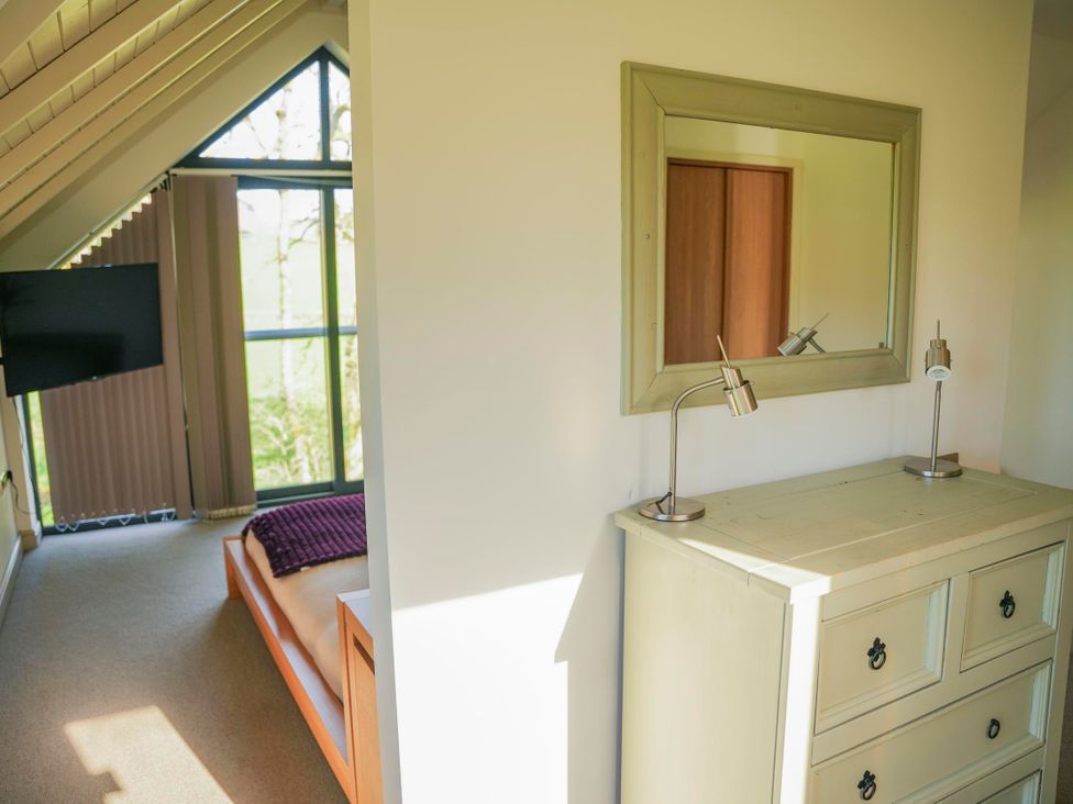 A bedroom with a dresser and television at Oak Lodge in Llangunllo