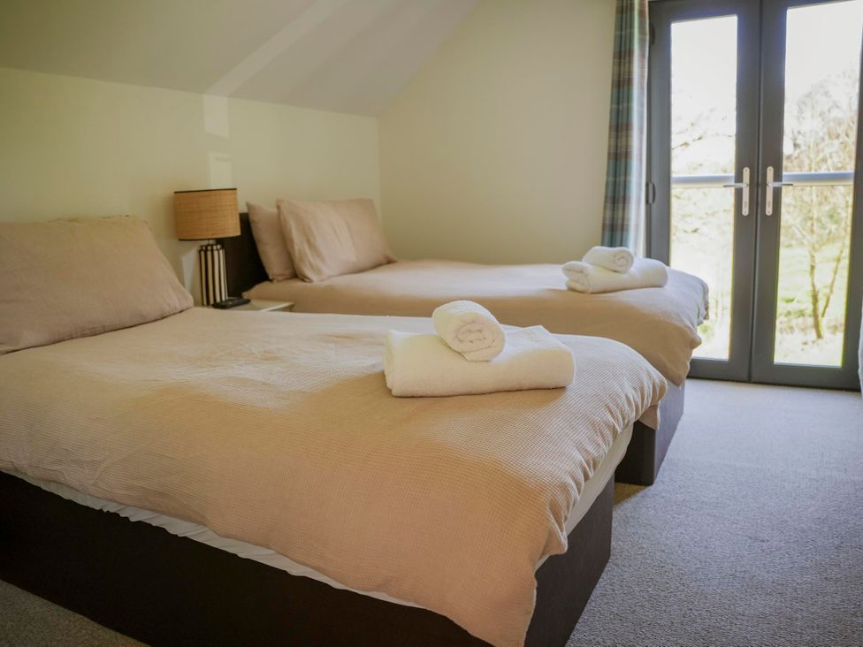 A bedroom with two beds and a window at Oak Lodge Llangunllo