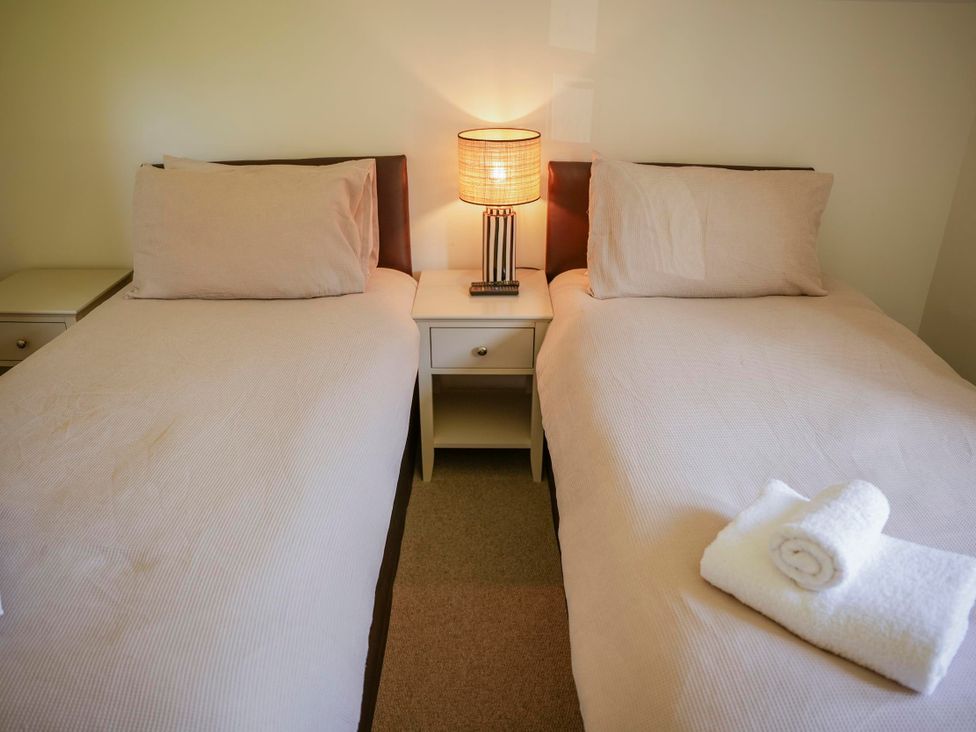 A bedroom with twin beds and a bedside table at Oak Lodge Llangunllo