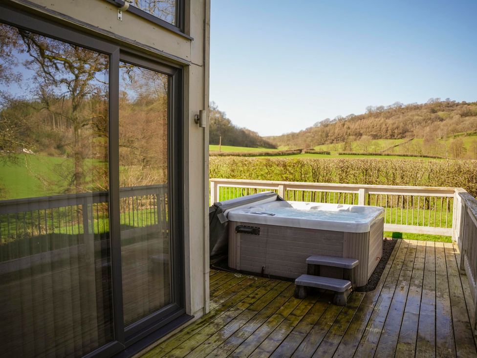 An outdoor area with a hot tub on the deck at Oak Lodge in Llangunllo