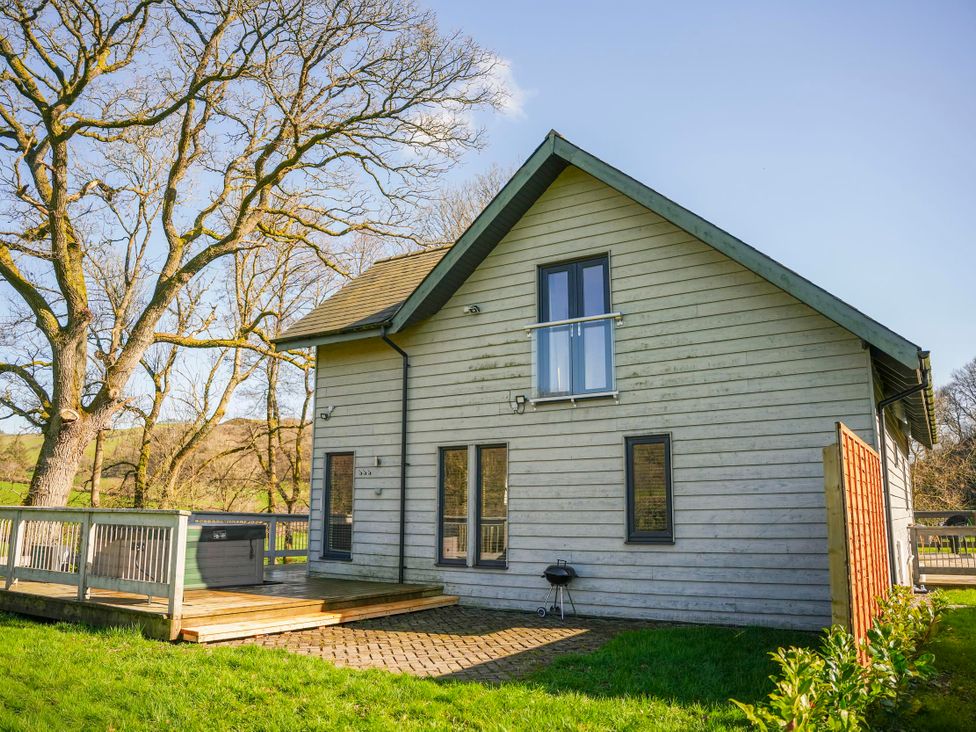 A house with a deck and hot tub at Oak Lodge in Llangunllo