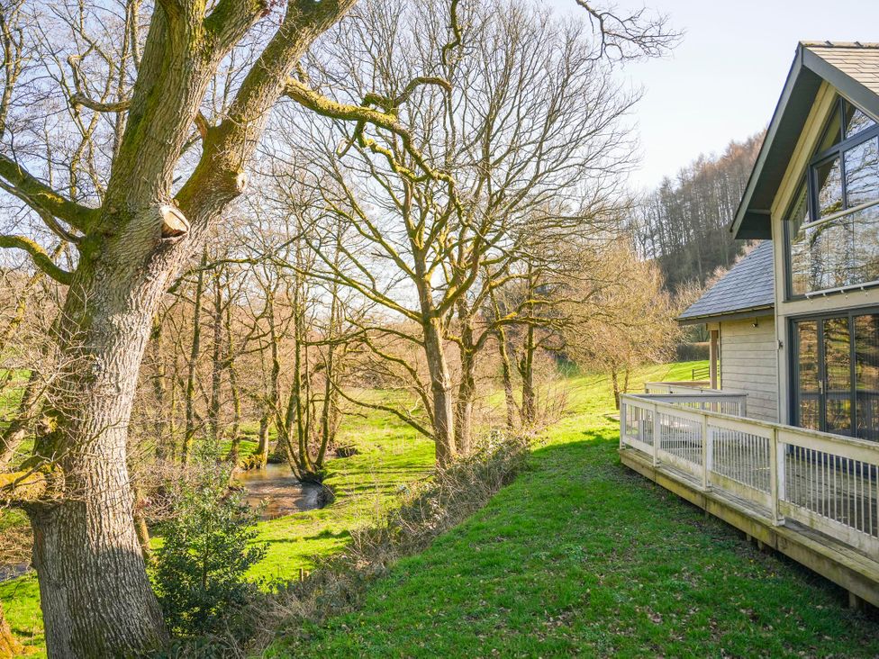 A view of a tree and stream next to a building at Oak Lodge Llangunllo