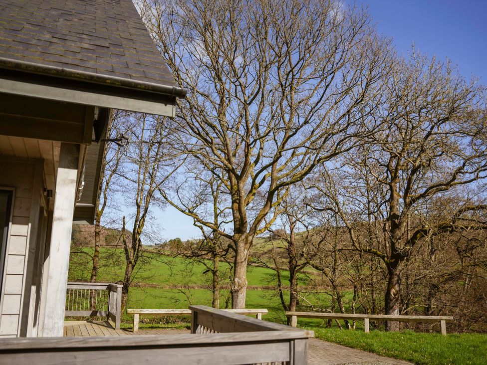 A view of trees and grass from the deck of the house at Oak Lodge Llangunllo