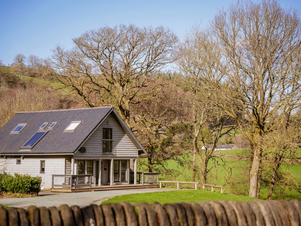 A house surrounded by trees and grass at Oak Lodge in Llangunllo