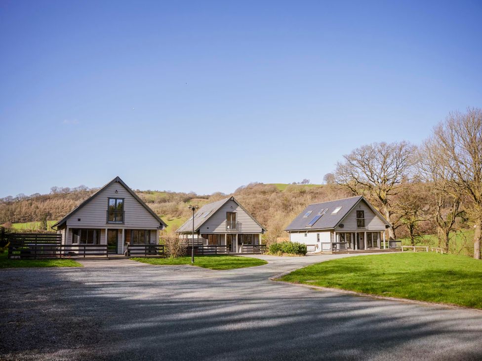 Three houses situated by a gravel driveway at Oak Lodge in Llangunllo