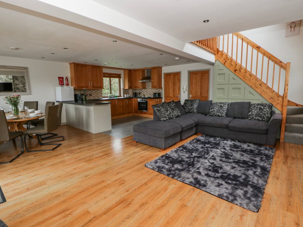 A living room with a sofa and dining table at Willow Lodge in Knighton