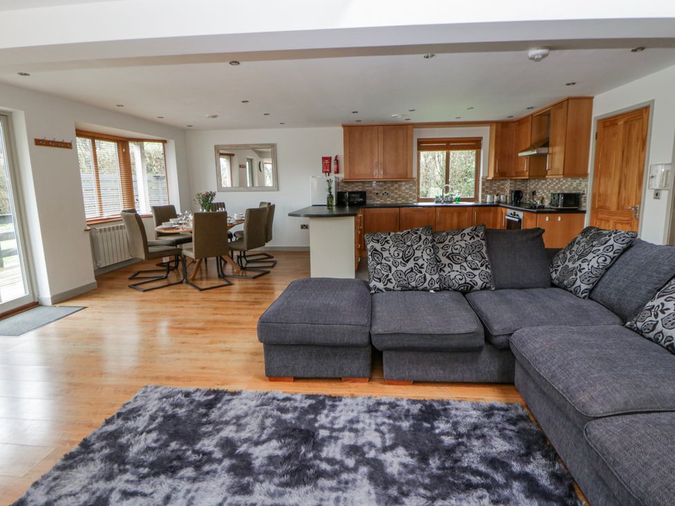 A living room with a sofa and dining table at Willow Lodge in Knighton