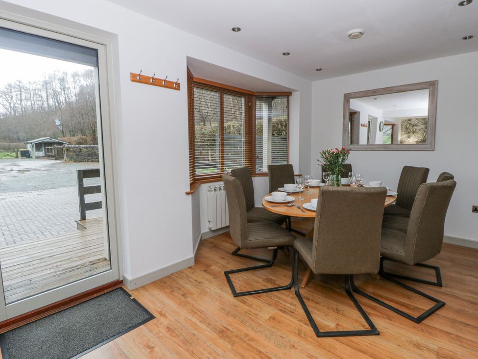 A dining room with a round table and chairs at Willow Lodge in Knighton