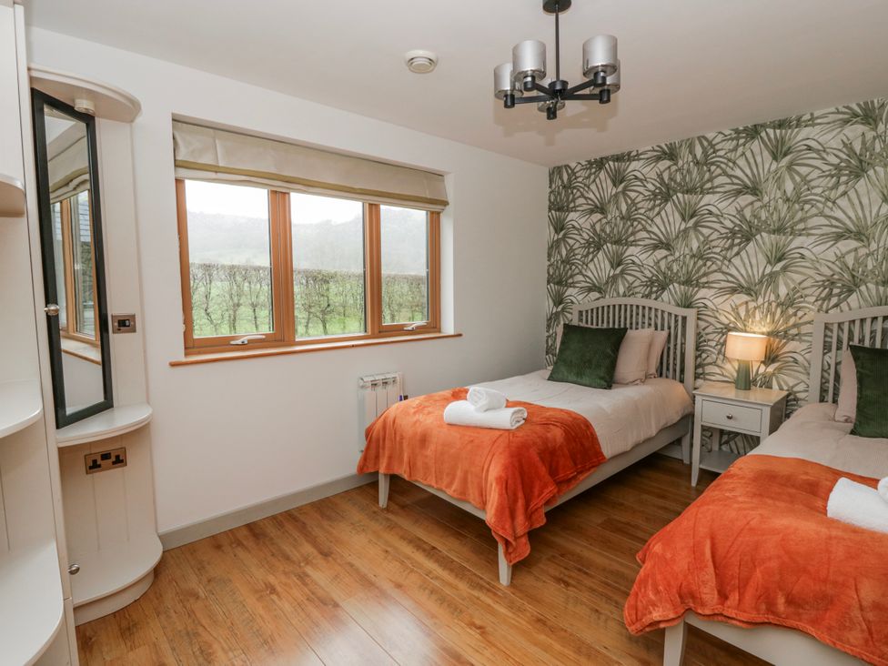 A bedroom with two beds and a window at Willow Lodge in Knighton