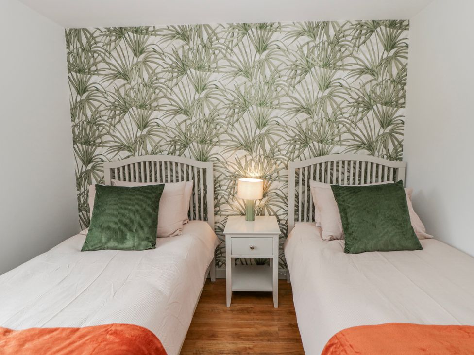 A bedroom with two beds and a lamp at Willow Lodge in Knighton