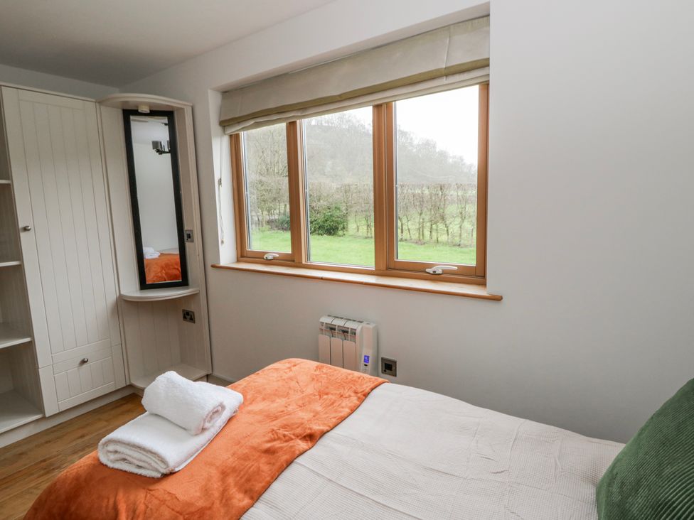 A bedroom with a bed and window at Willow Lodge in Knighton