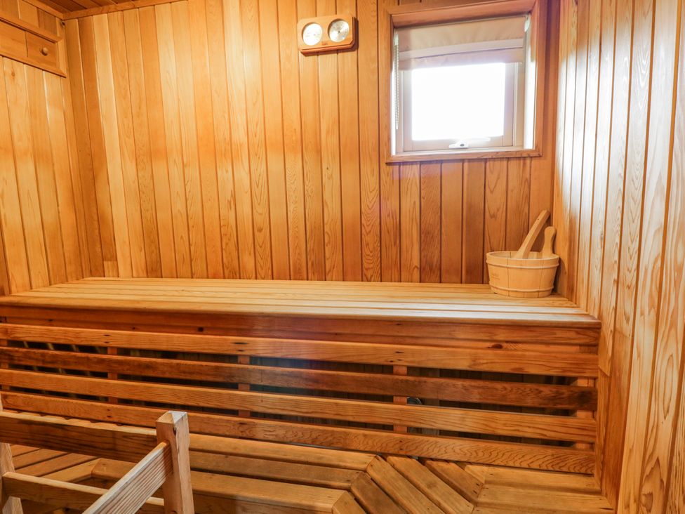A sauna with wooden benches and a bucket at Willow Lodge in Knighton
