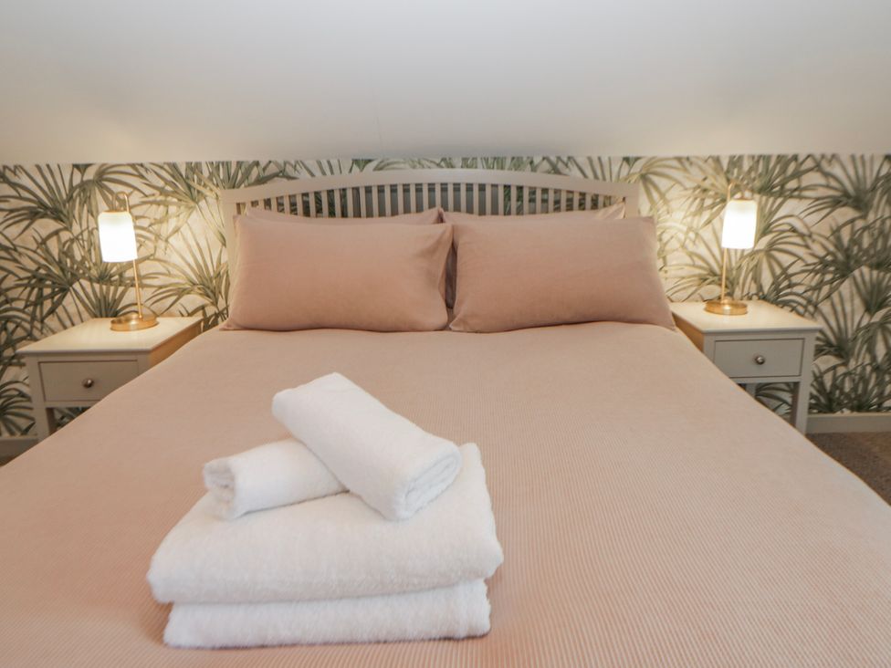 A bedroom with a bed and towels placed on top at Willow Lodge in Knighton