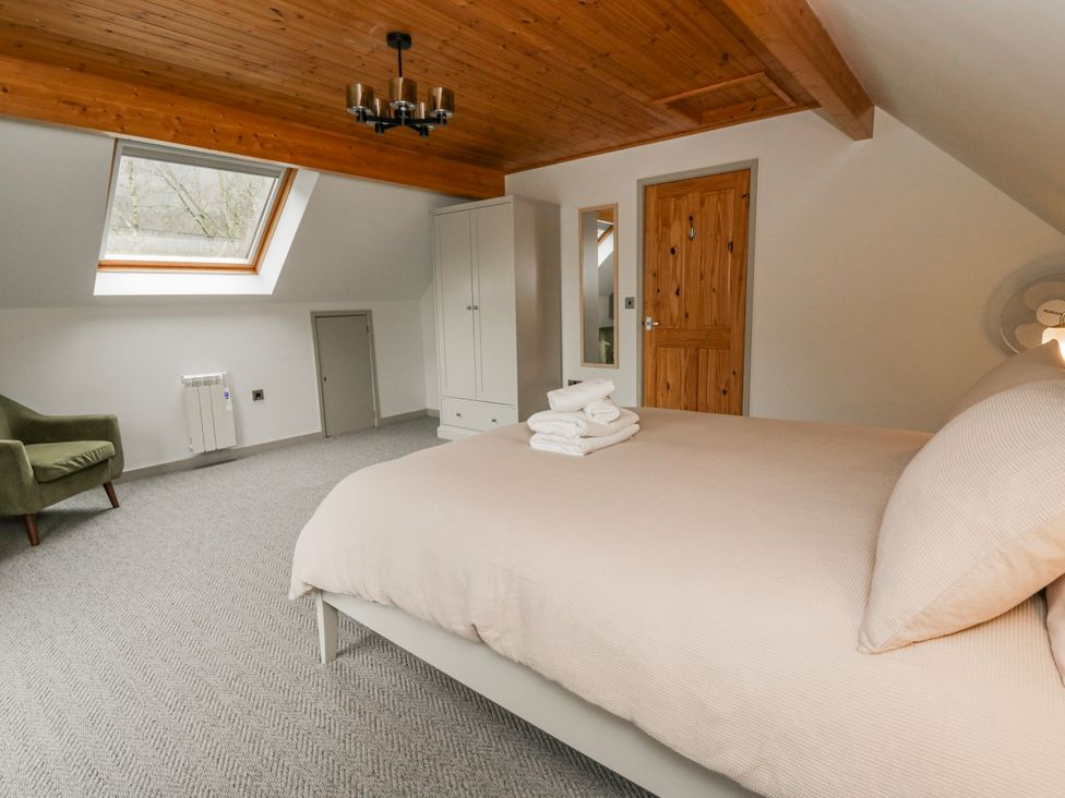 A bedroom with a bed and a chair at Willow Lodge Knighton