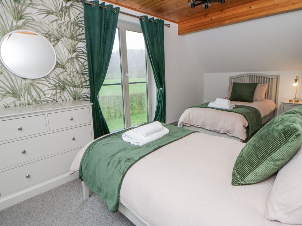 A bedroom with two beds and a dresser at Willow Lodge in Knighton