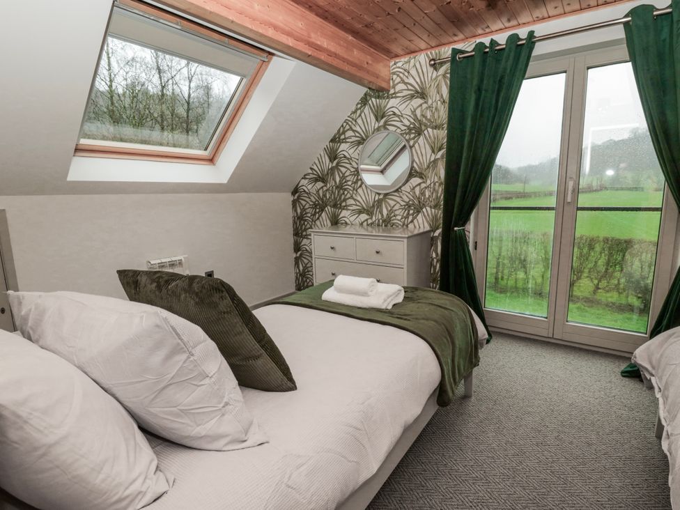 A bedroom with a bed and dresser at Willow Lodge in Knighton