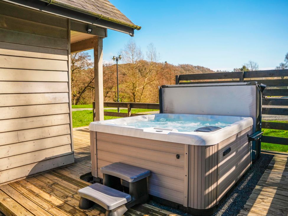 A hot tub with steps on a wooden deck at Willow Lodge in Laceby