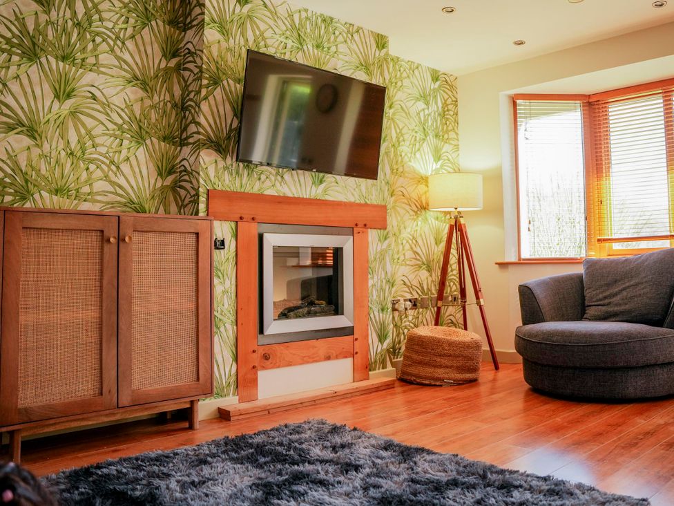 A living room with a fireplace and television at Willow Lodge in Laceby