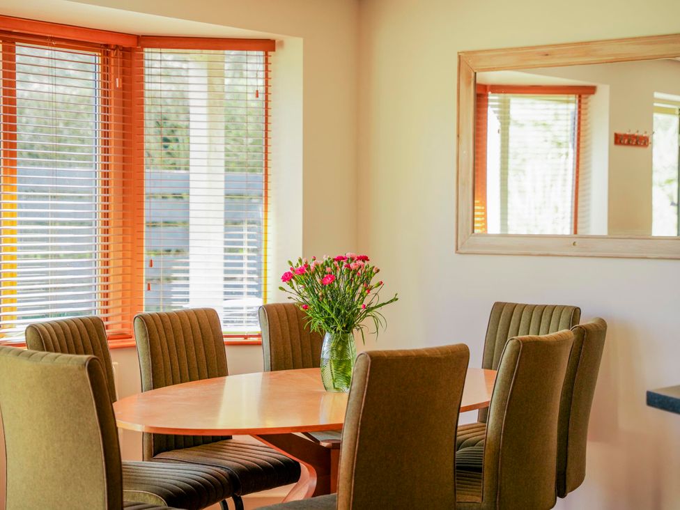 A dining room with a table and chairs at Willow Lodge in Laceby