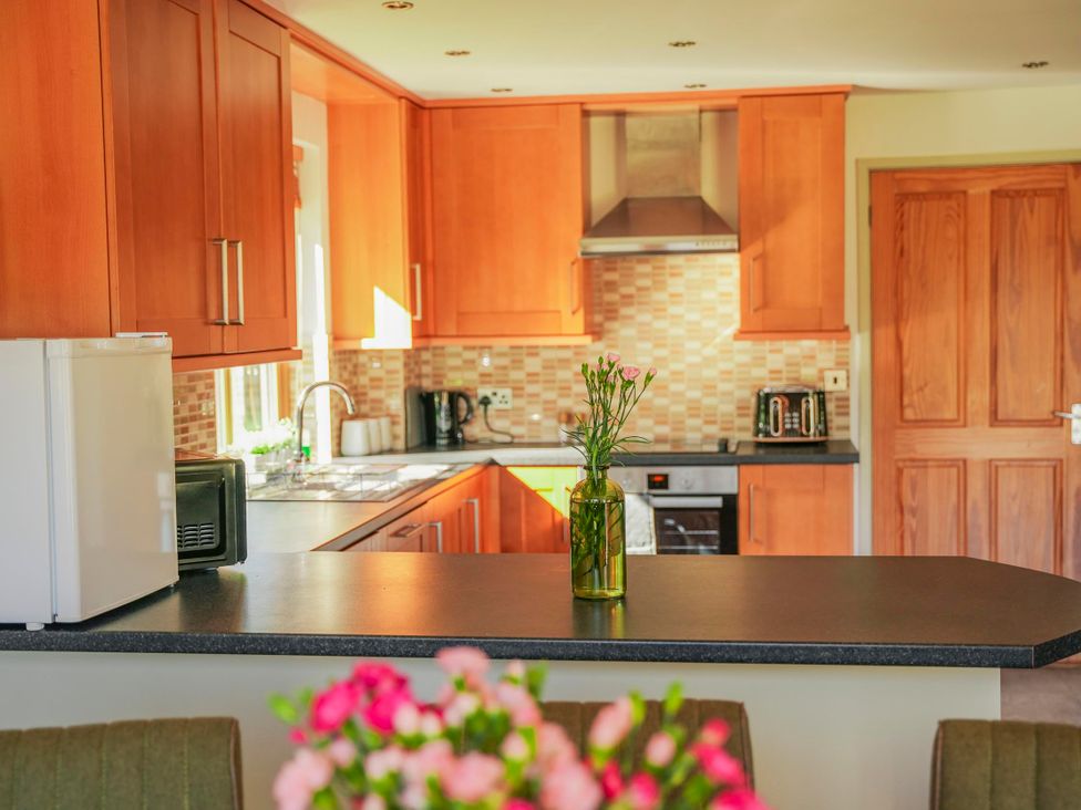 A kitchen with cabinets and appliances at Willow Lodge Laceby