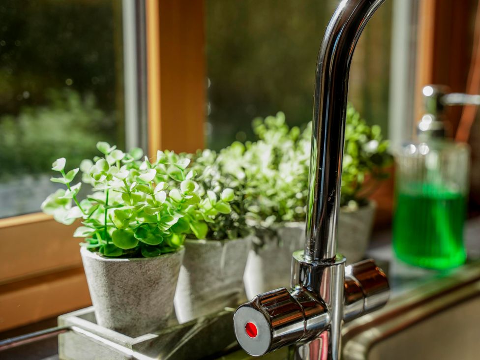 A kitchen with potted plants near a faucet at Willow Lodge in Laceby