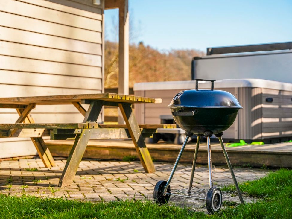 A grill and picnic table on the patio at Willow Lodge in Laceby