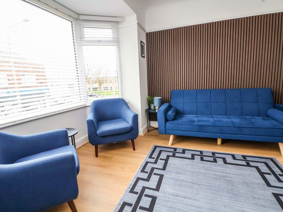 A living room with a blue sofa and armchairs at Wallasey Village Escape by the Sea Wallasey