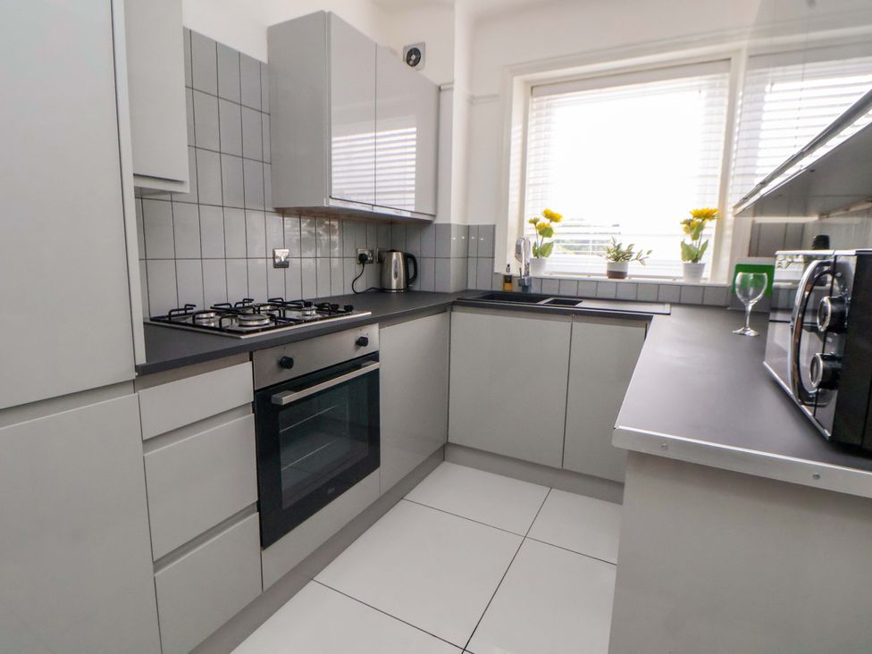 A kitchen with a gas stove and sink at Wallasey Village Escape by the Sea in Wallasey