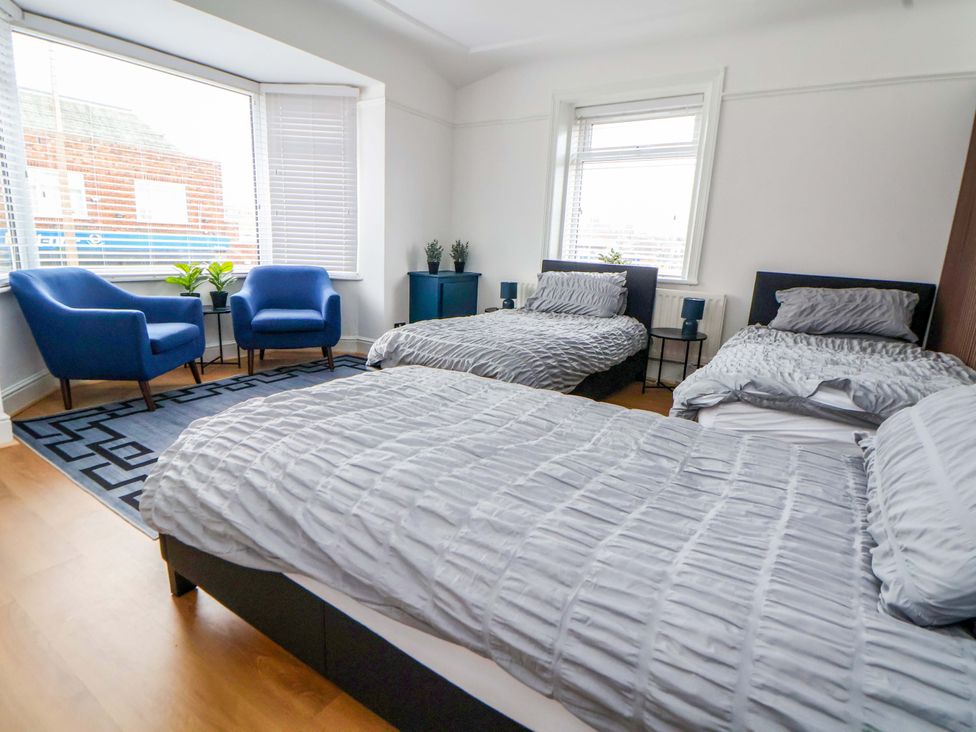 A bedroom with two beds and armchairs at Wallasey Village Escape by the Sea, Wallasey